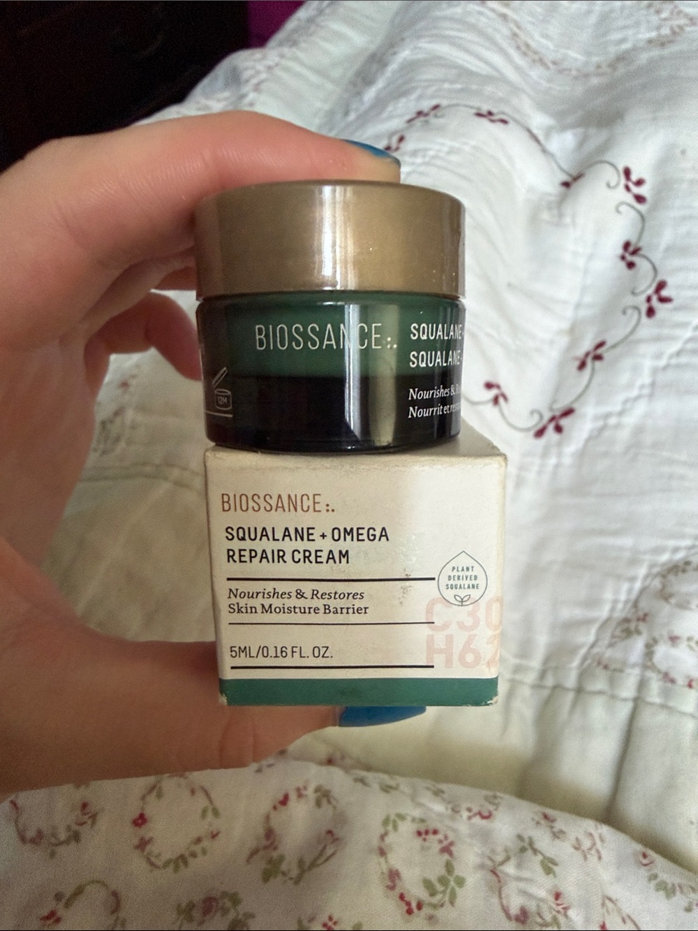Biossance moisturizer jar in green with gold lid